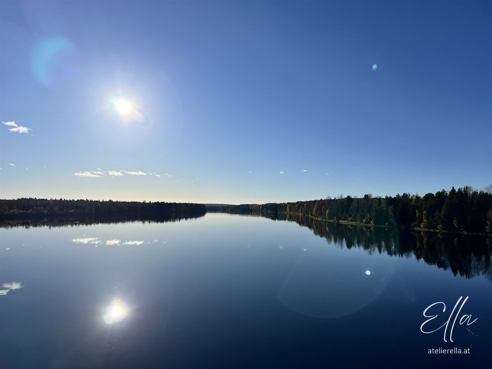 Sonne spiegelt sich in einem stillen See in Lappland