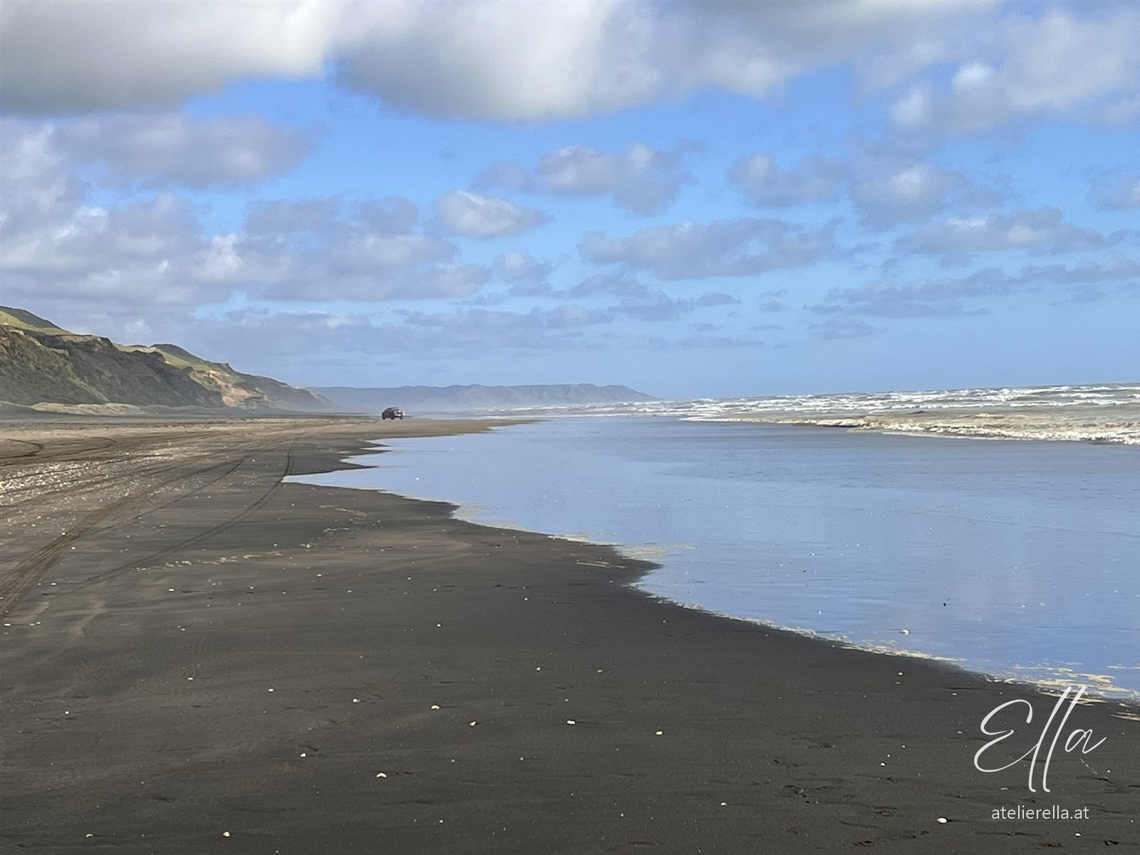 Schwarzer Sandstrand von Karioitahi an der Westküste Neuseelands unter Wolkenhimmel