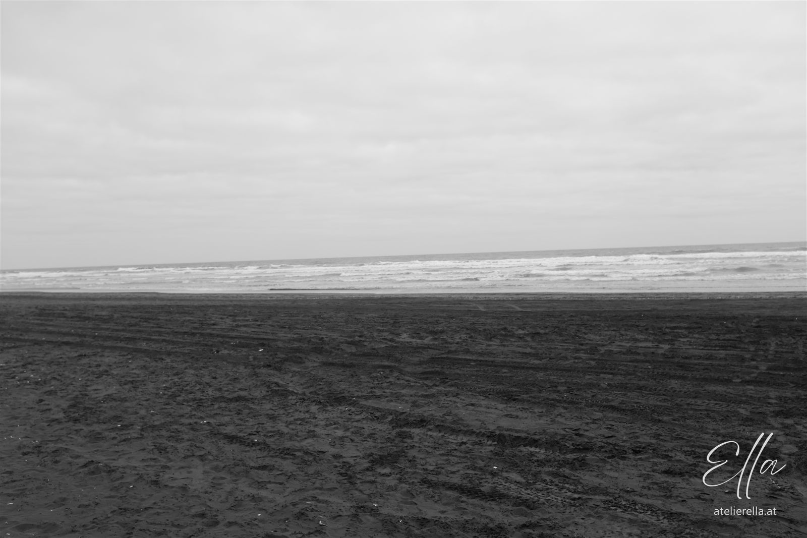 Weiter Strand und Brandung in Schwarz-Weiß