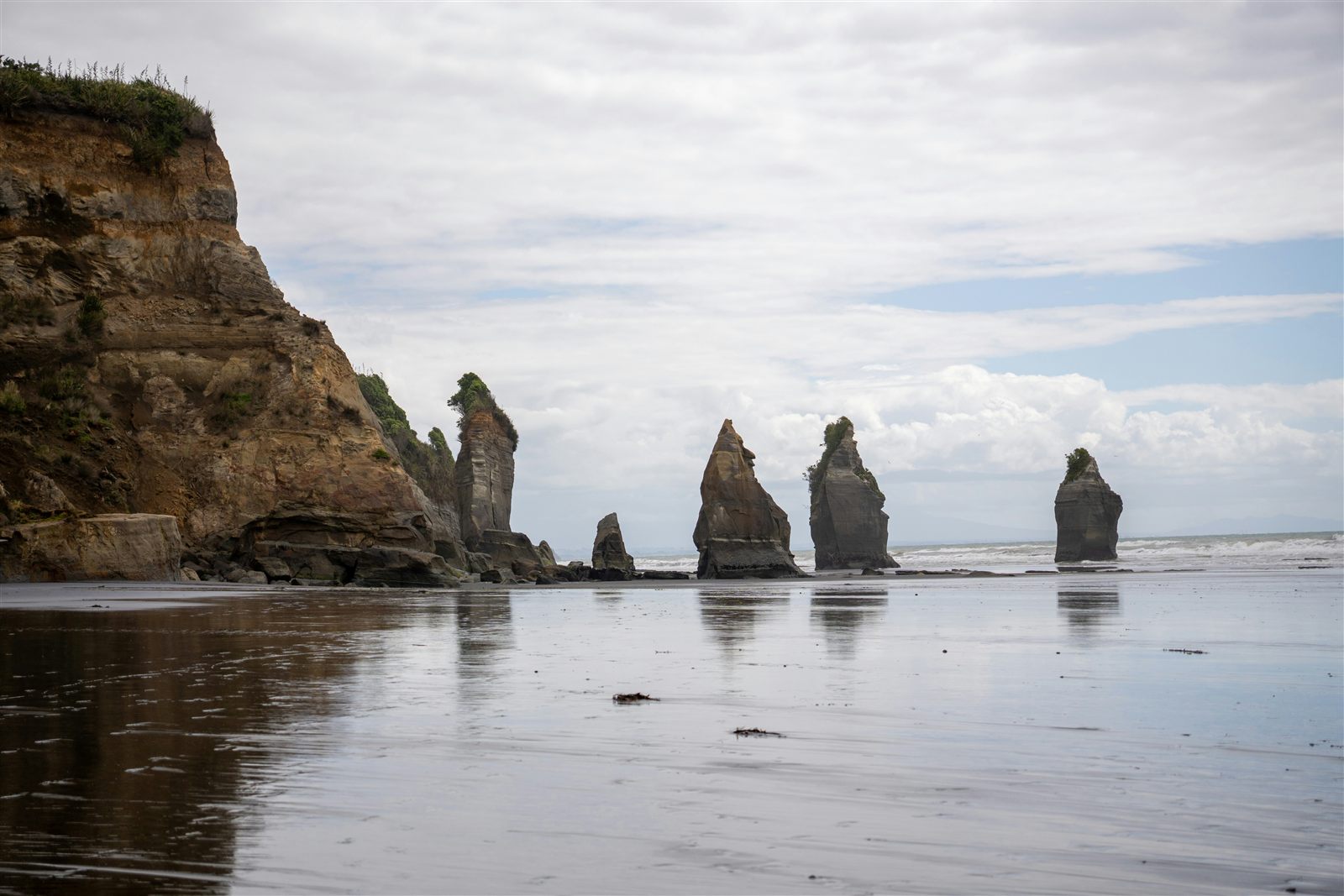 Felsformationen Three Sisters ragen bei Tongaporutu aus dem spiegelnden Meer