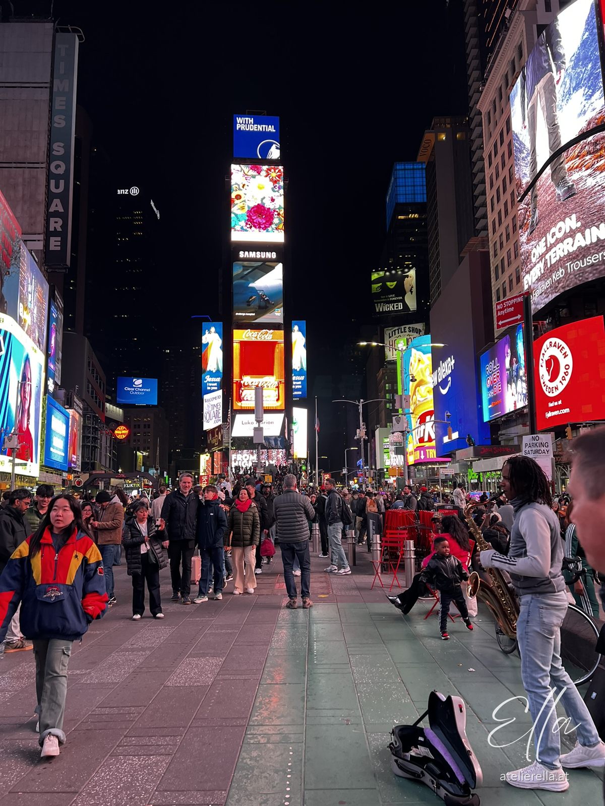 Times Square bei Nacht mit leuchtenden Werbetafeln und vielen Menschen