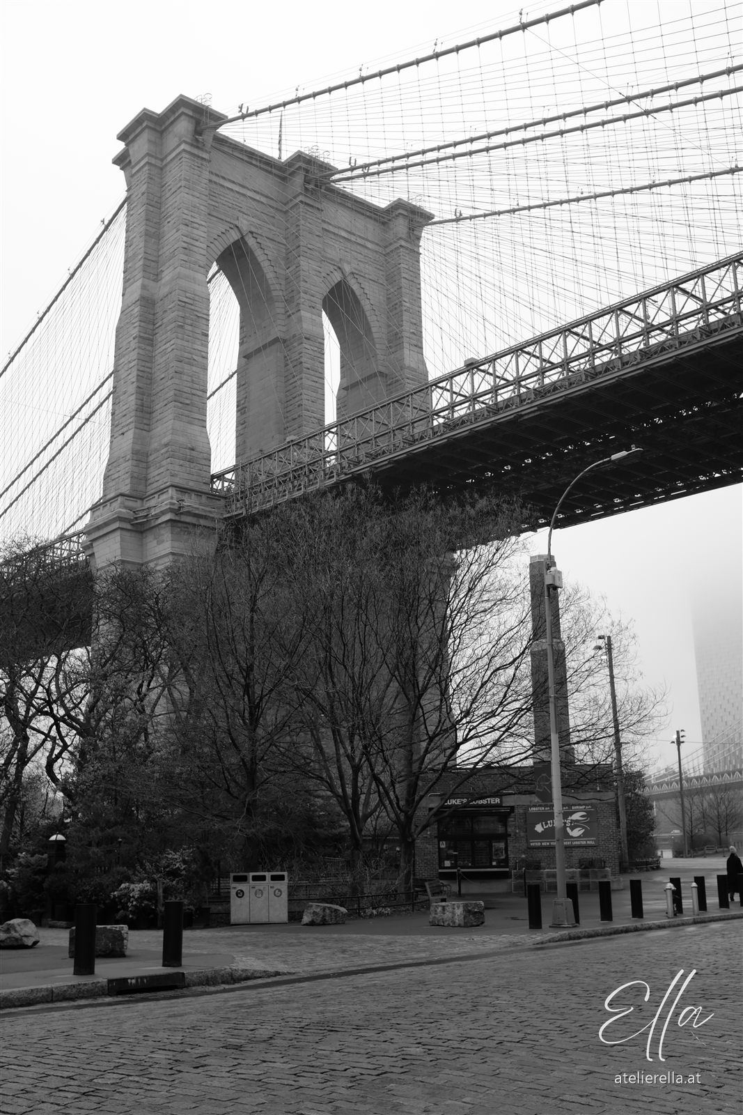 Brooklyn Bridge von unten mit Steinbogen und Seilen, schwarz-weiß